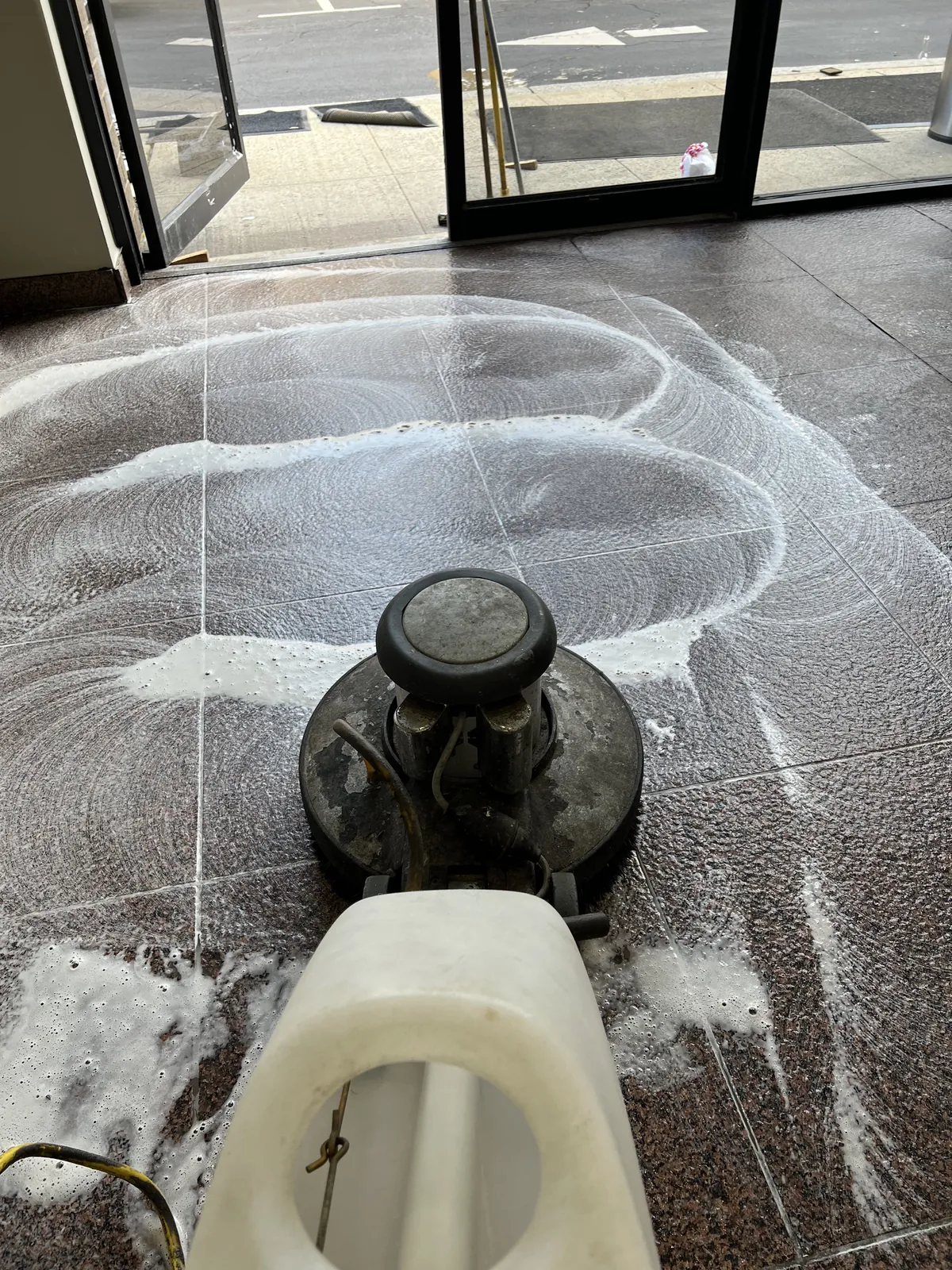 Floor machine scrubbing tile